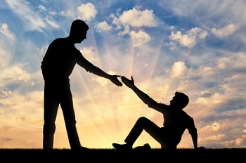 une personne tend la main à une autre personne pour la relever